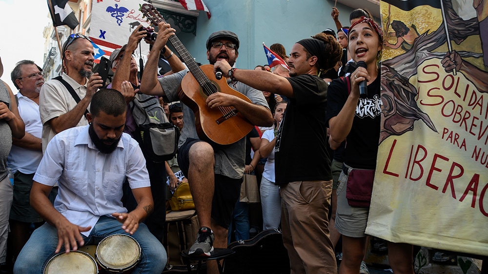 Members of theatre group Papel Machete perform during a protest calling for the resignation of Governor Rossello in front of La Fortaleza in San Juan