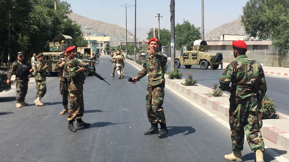 Afghan security forces cordoned off the road near the site of the blast as government troops battled Taliban fighters holed up inside a nearby building