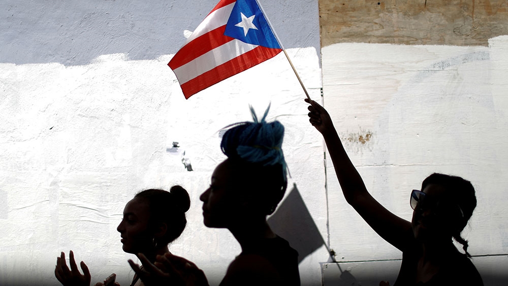 A woman waves a Puerto Rican flag during the ongoing protests calling for the resignation of Governor Rossello in San Juan