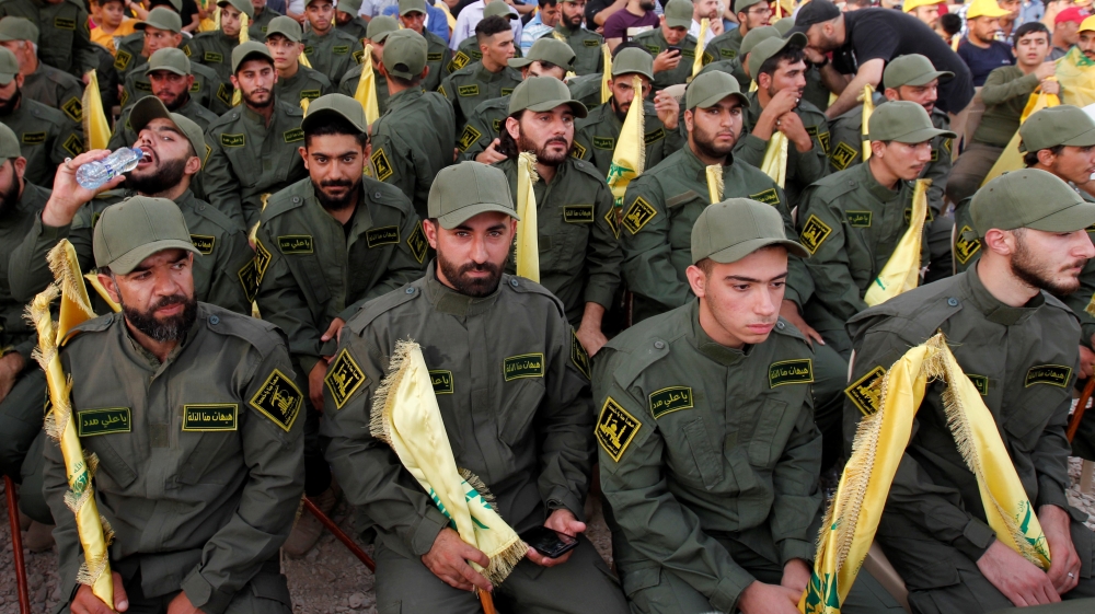 Lebanon's Hezbollah members hold party flags as they listen to their leader Sayyed Hassan Nasrallah 
