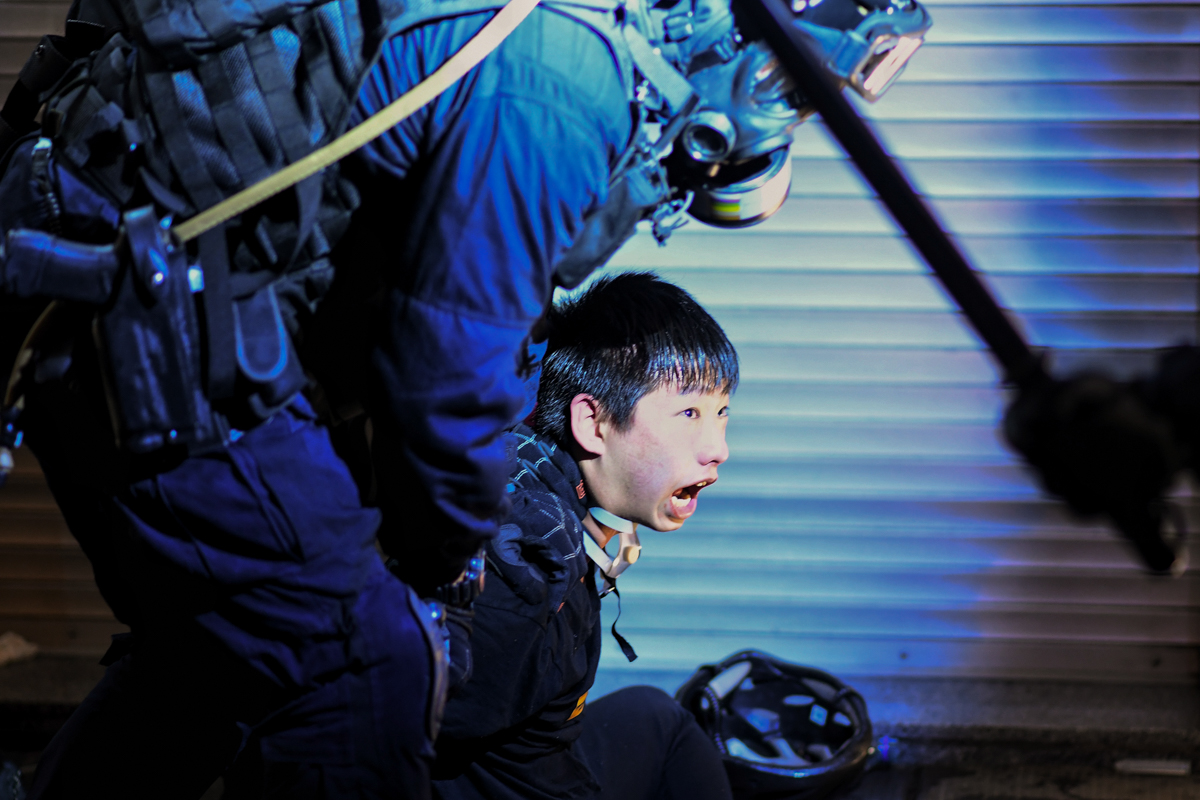 A pro-democracy protester is held by police outside Tsim Sha Tsui Police station during a demonstration against the controversial extradition bill in Hong Kong on August 11, 2019. - Empty hotel rooms,