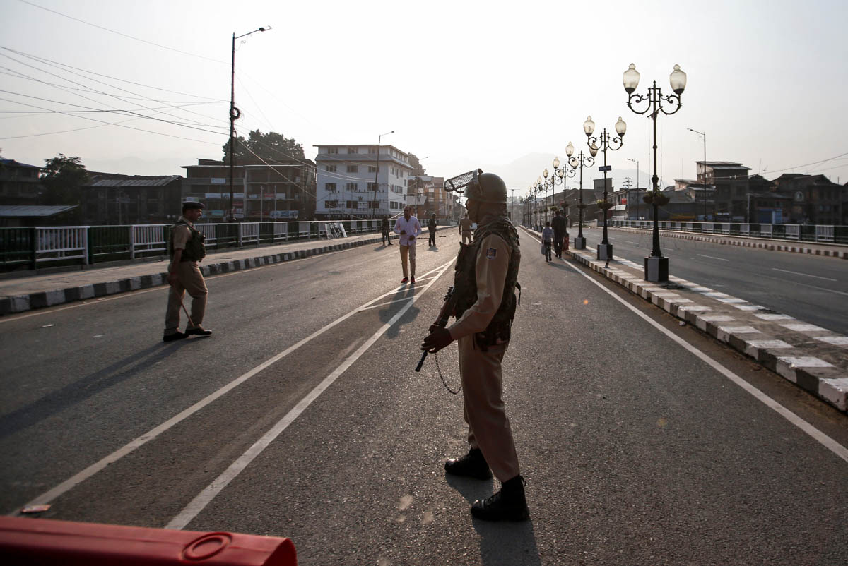 Indian security personnel stand guard on a deserted road during restrictions in Srinagar, August 5, 2019. REUTERS/Danish IsmailIndian security personnel stand guard on a deserted road during restricti