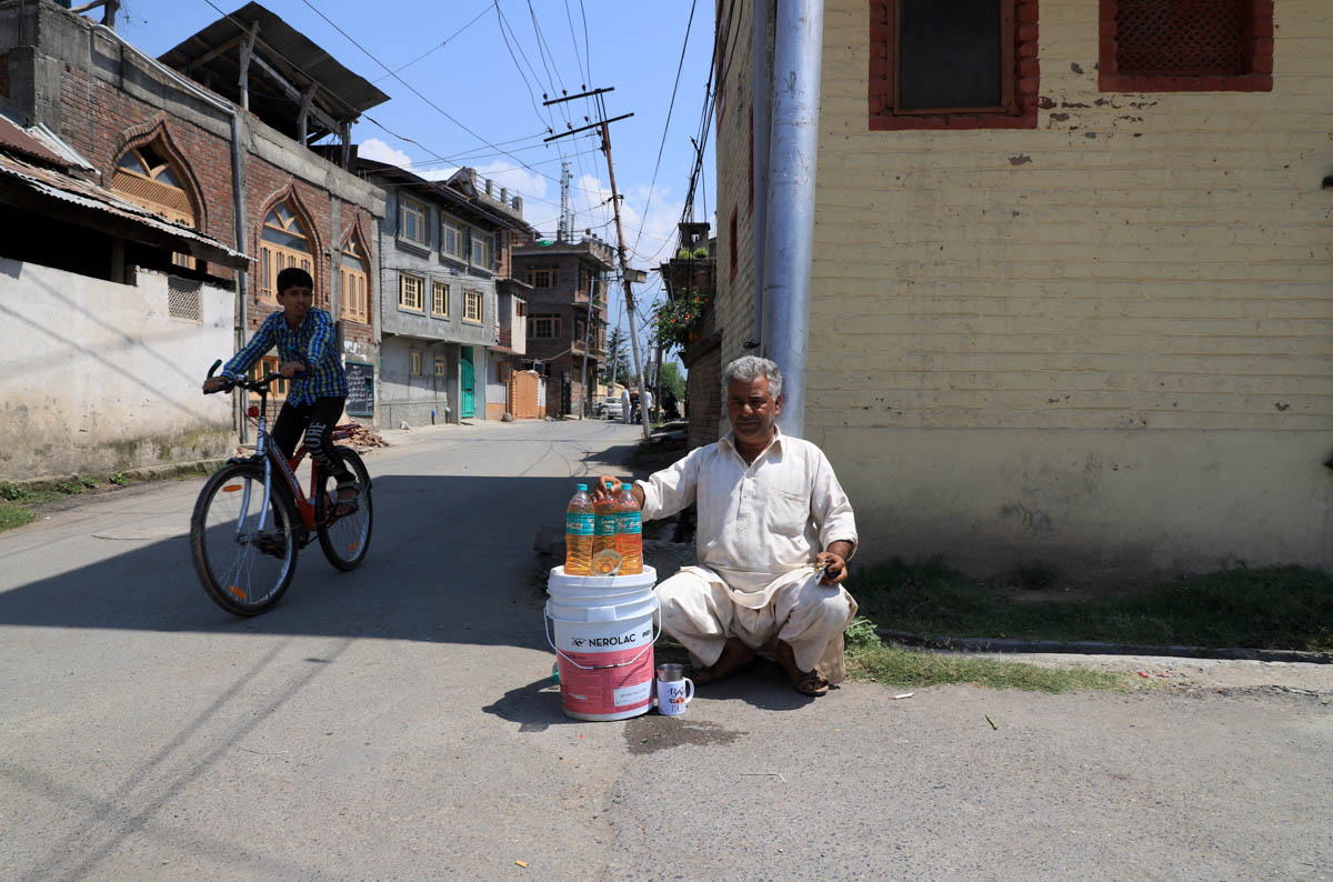 Muhammad Ayoub an auto rikshaw driver sells petrol bottles outside his house in rainawariSrinagar,Ayoub says I used to earn an handsome amount of money by riding rickshaw in the city I had no option o