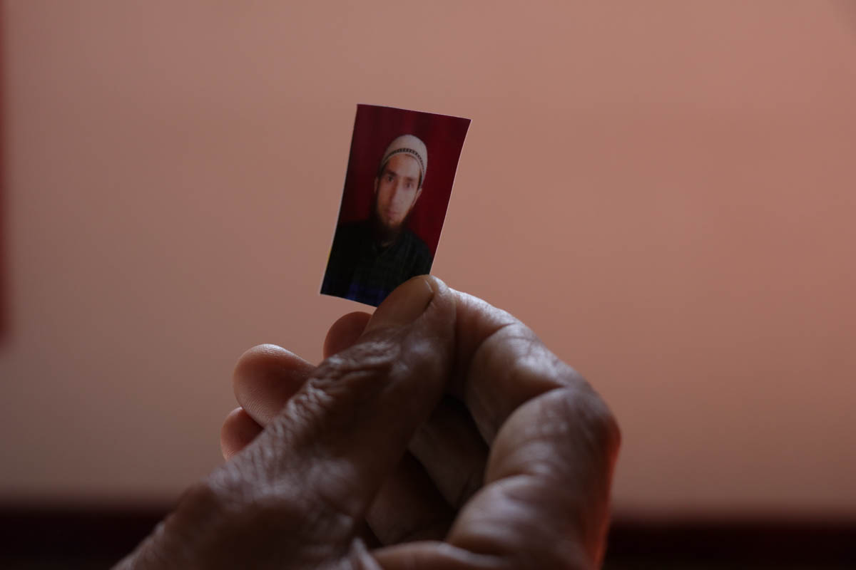 Rehmandar holds portrait of his son bilalahmaddar who was picked up by government forces from his house during midnight in kareemabad village of south Kashmir , Bilal was charged with Public safety