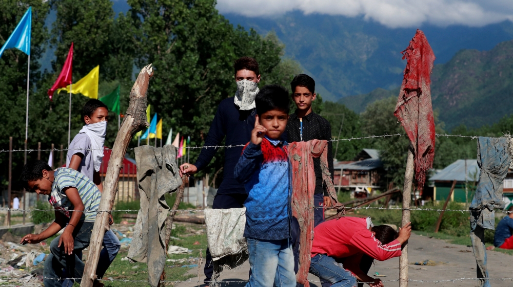 Kashmiri protesters stand at a barricade to block the entrance of a neighbourhood, during restrictions after the scrapping of the special constitutional status for Kashmir by the government