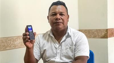 Jesus Alean shows the mobile phone he was given by the Colombian National Protection Unit