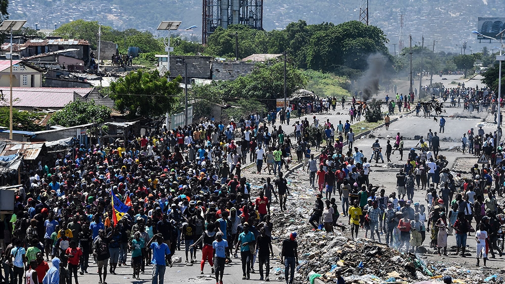 People march in Cite Soleil during a protest in demand of the resignation of President Jovenel Moise