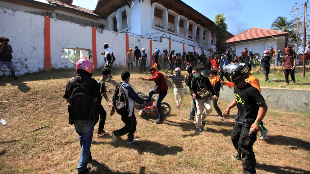 Protesters are seen outside the local parliament building during a protest in Kendari