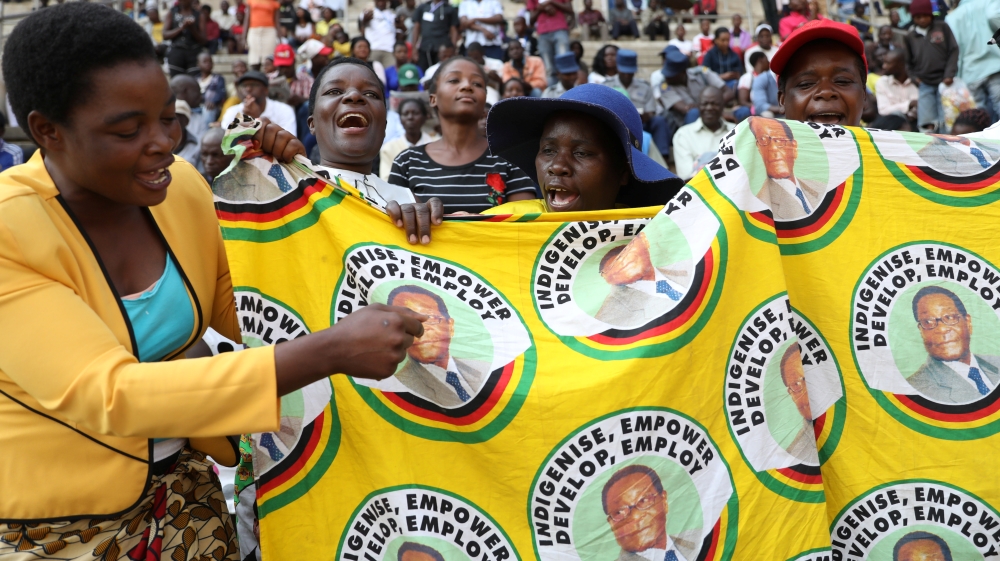 Mourners sing ahead of a state funeral for Mugabe at a national sports stadium in Harare