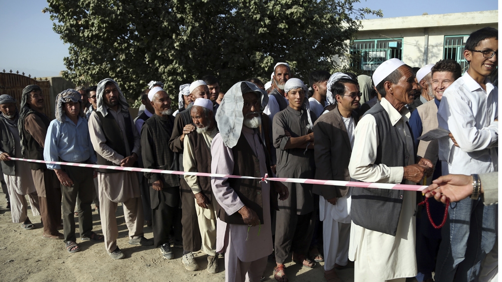 Men line up outside a polling station in a western neighbourhood of Kabul