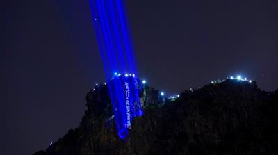 As darkness fell on Friday night, protesters armed with flashlights, mobile phones and lanterns gathered at Victoria Peak and Lion Rock