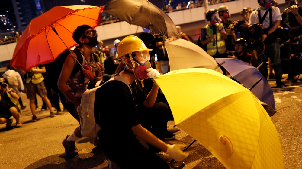 A protester shelters behind an umbrella during a rally on Saturday. Protests began in June over an extradition bill, but have morphed into a broader call for more democracy.