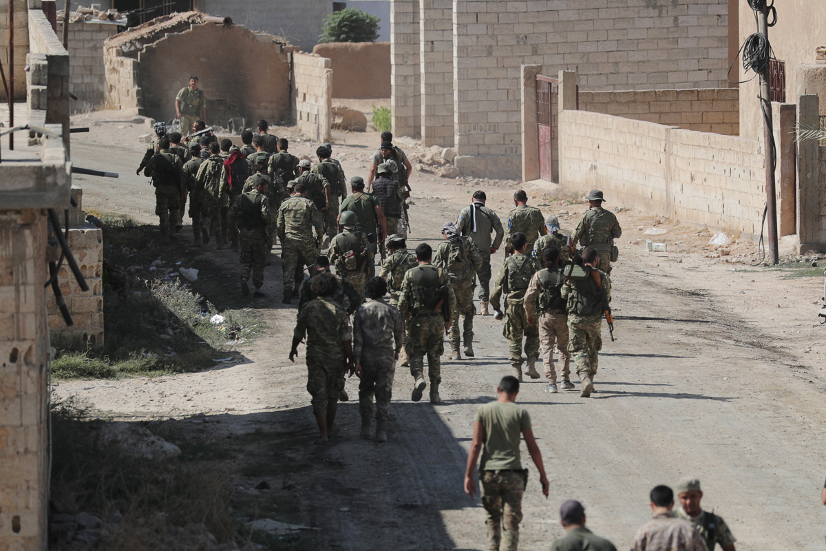 Turkey-backed Syrian rebel fighters walk together near the border town of Tel Abyad, Syria, October 12, 2019. REUTERS/Khalil Ashawi