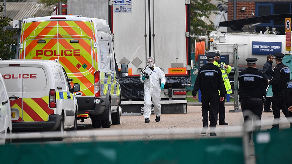 British Police officers in forsensic suits work near a lorry, found to be containing 39 dead bodies, as they work inside a police cordon at Waterglade Industrial Park in Grays, east of London, on Octo