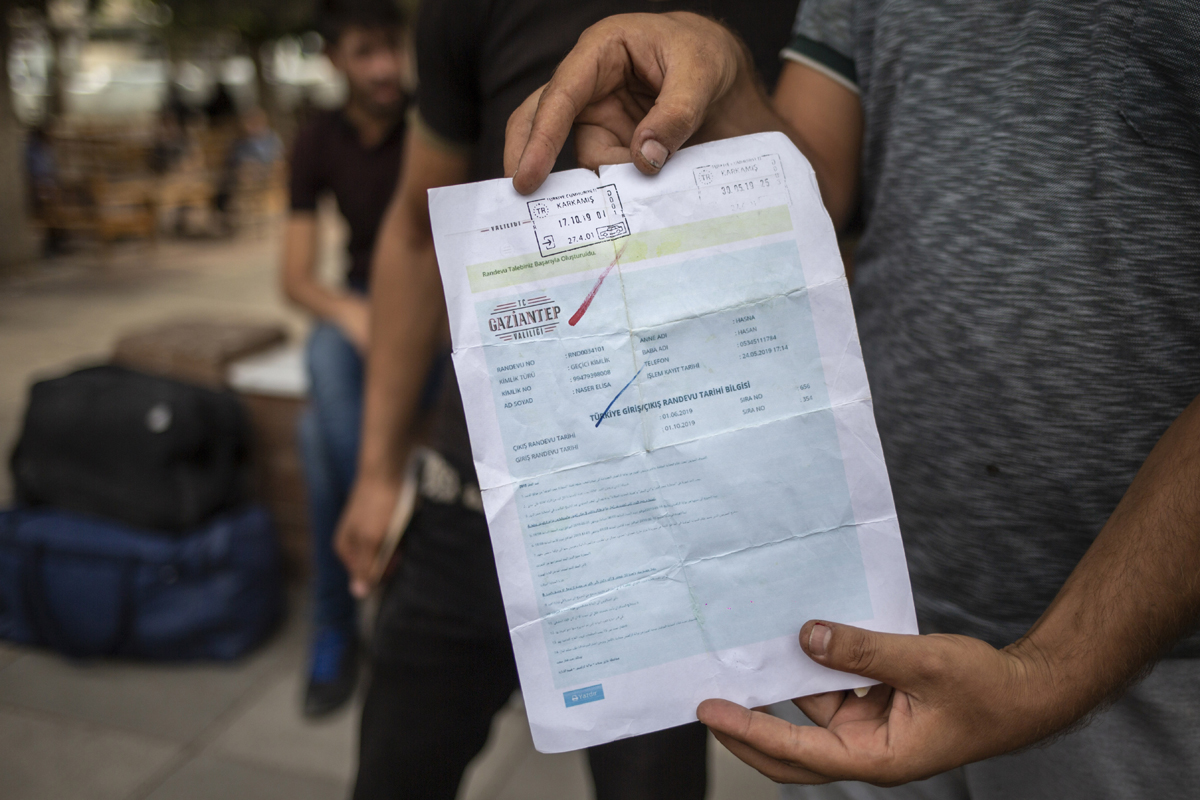 A man flashes his entry stamp as he waited to board a bus to Gaziantep’s suburbs