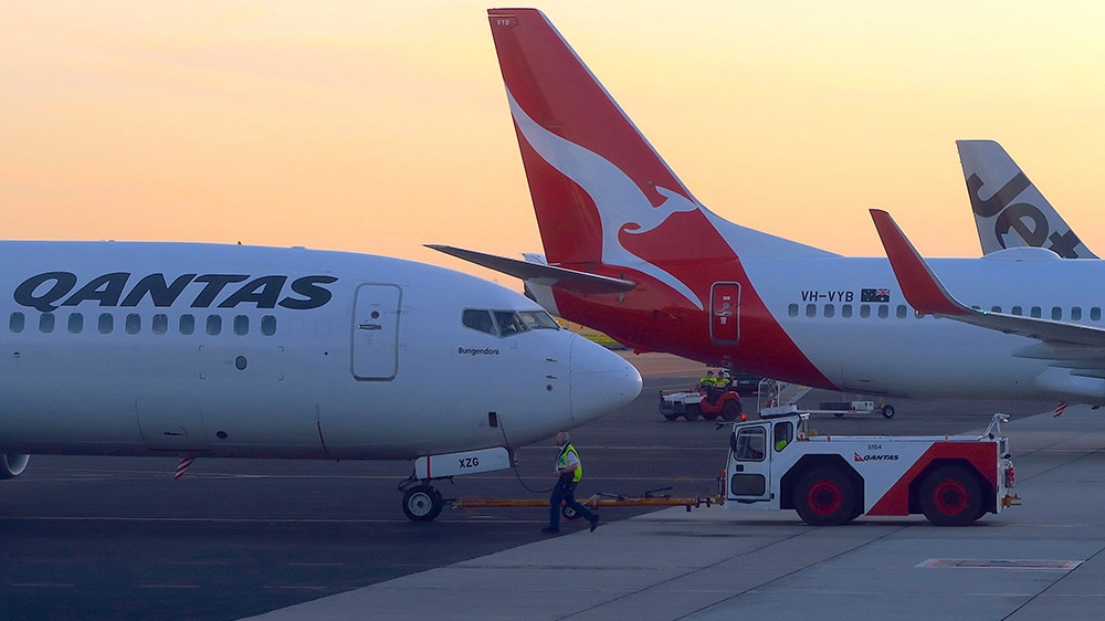 Workers are seen near Qantas Airways, Australia''s national carrier, Boeing 737-800 aircraft on the tarmac at Adelaide Airport, Australia, August 22, 2018