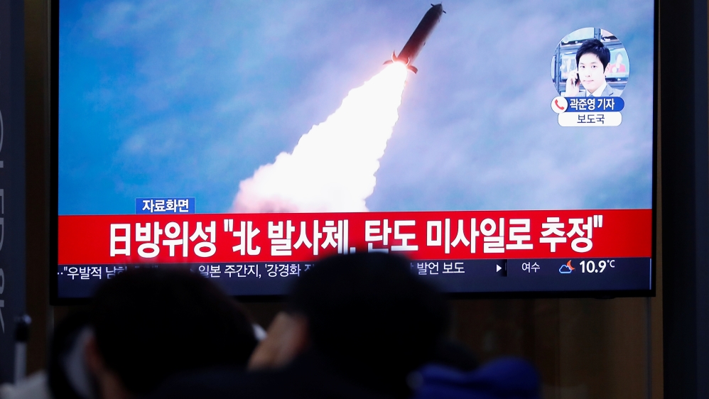 People watch a TV broadcasting file footage for a news report on North Korea firing an unidentified projectile, in Seoul
