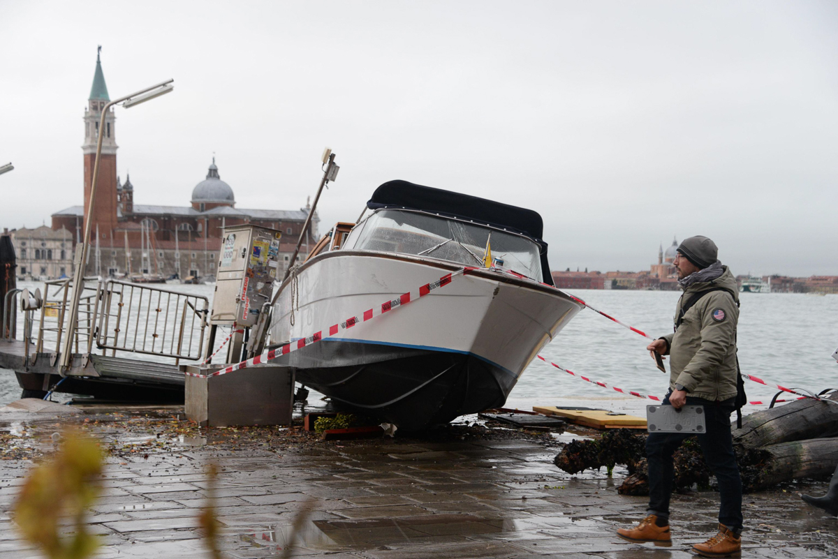 epa07992231 A view of a boat stranded on the docks following bad weather in Venice, northern Italy, 13 November 2019. A wave of bad weather has hit much of Italy on 12 November. Levels of 100-120cm ab