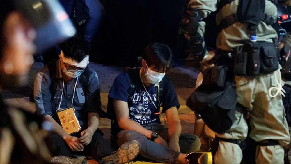 Police interrogate protesters who left the occupied campus of the Hong Kong Polytechnic University on Monday night.
