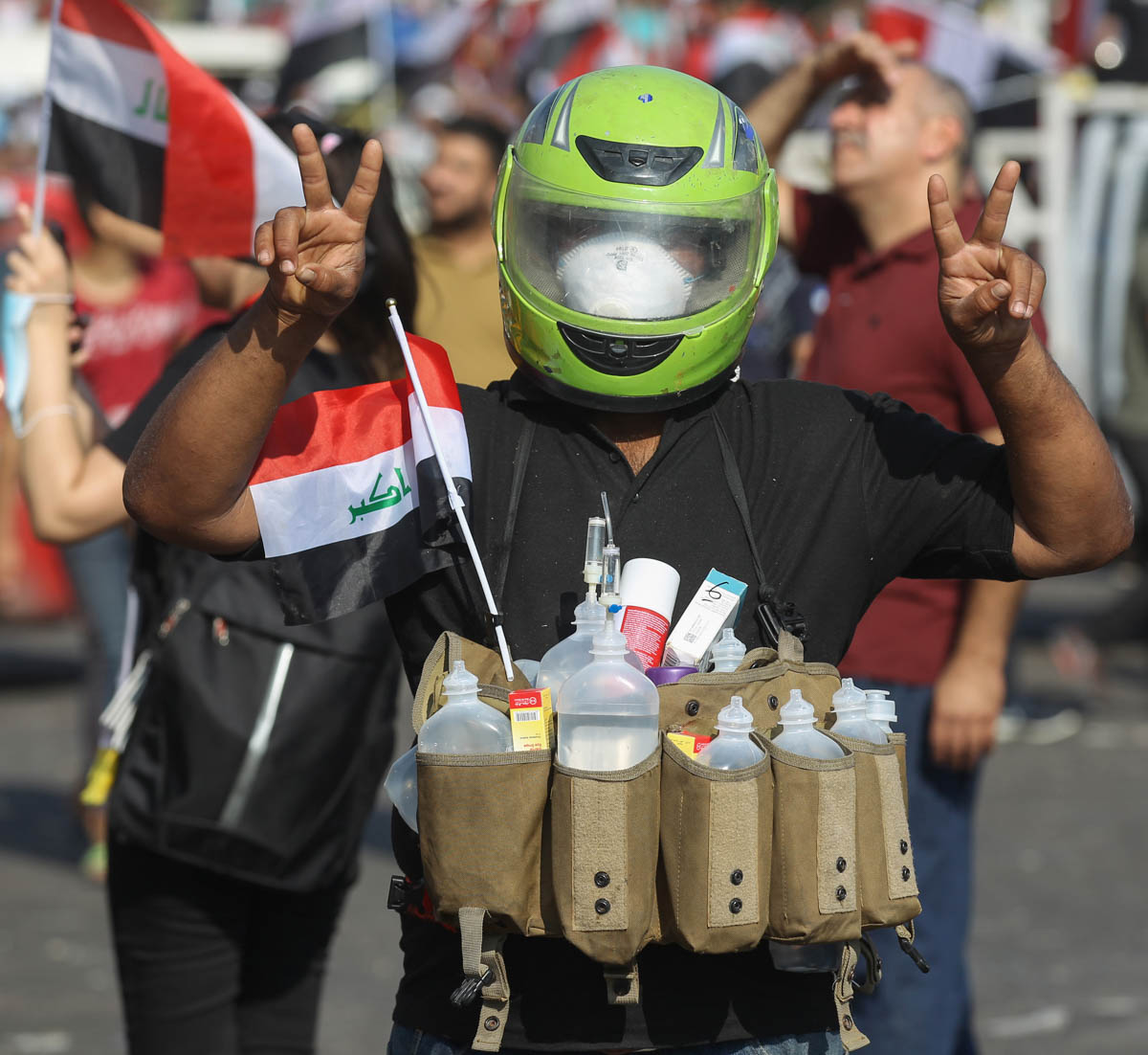 An anti-government protester hangs on his makeshift gear bottles of solution to relieve the effects of tear gas, fired by riot police against demonstrators in Baghdad’s Tahrir Square during continuing