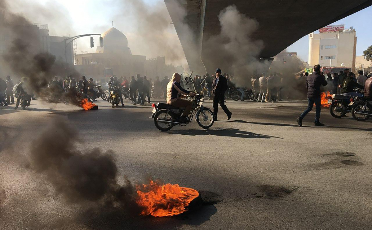 Iranian protesters rally amid burning tires during a demonstration against an increase in gasoline prices, in the central city of Isfahan on November 16, 2019. - One person was killed and others injur