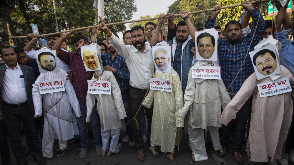 AASU activists hang the effigies of Indian Prime Minister Narendra Modi, centre, Home Minister Amit Shah, second from left, and Assam Chief Minister Sarbananda Sonowal, second from right, along with some other leaders’, during a protest against the Citizenship Amendment Bill in Guwahati