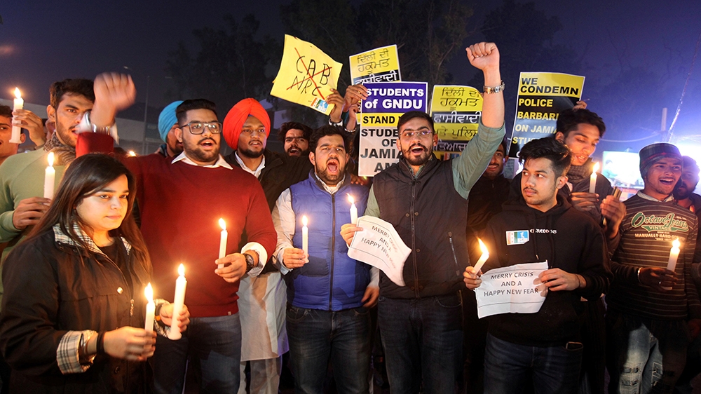 Demonstrators holding candles and placards shout slogans during a protest against a new citizenship law and to show solidarity with the students of New Delhi''s Jamia Millia Islamia university after po