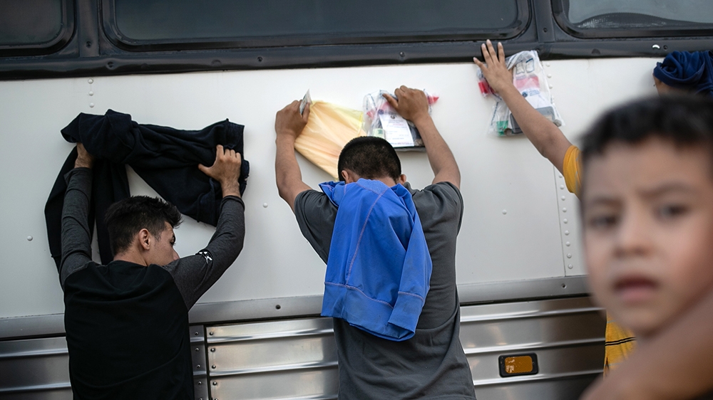 LOS EBANOS, TEXAS - JULY 02: Immigrants wait to be searched and then bussed to U.S. Border Patrol facility in McAllen after crossing the border from Mexico on July 02, 2019 in Los Ebanos, Texas. Hundr