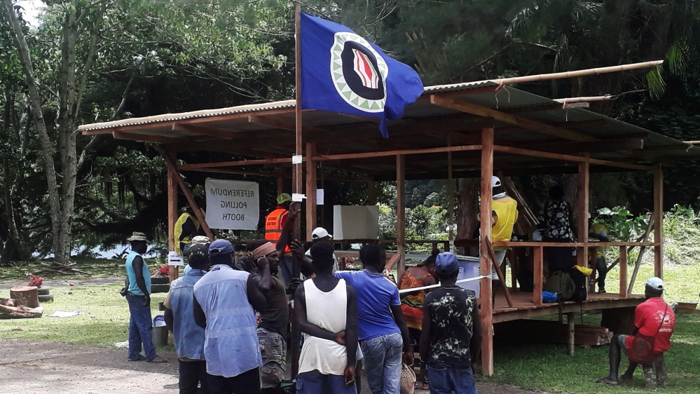 Residents hold a Bougainville flag at a polling station during a non-binding independence referendum in Arawa