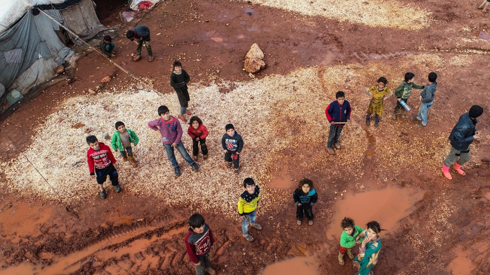 A drone photo shows Syrian children in a tent camp hosting families displaced due to attacks by the Assad government and Russia, as they try to live under harsh winter conditions in Idlib, Syria [Anadolu Agency]