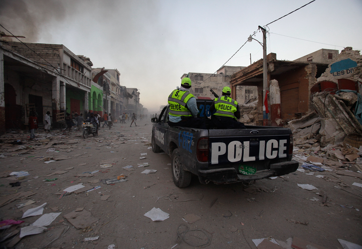 Police patrol through the streets of downtown Port-au-Prince trying to discourage looting on Sunday, Jan. 17, 2010. Haitian police scatter hundreds of people that scavenged for anything they could fin