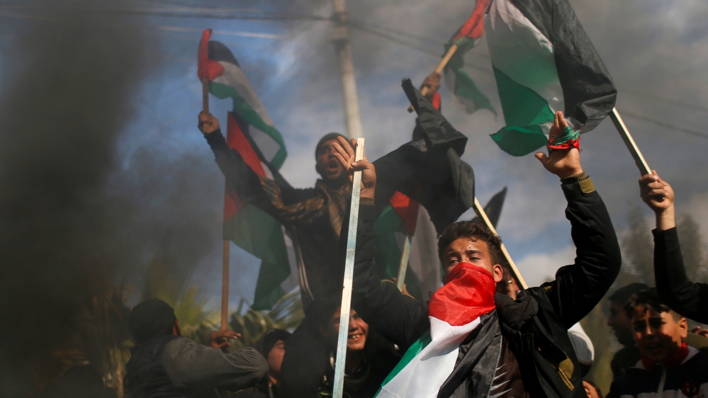 Palestinians protest as smoke rises from burning tires ahead of the announcement by U.S. President Donald Trump of his long-delayed Mideast peace plan, in Gaza City