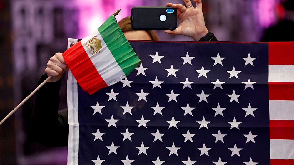 Attendees hold flags from Iran and the US as Iranian Americans from across California converge in Los Angeles to participate in the California Convention for a Free Iran