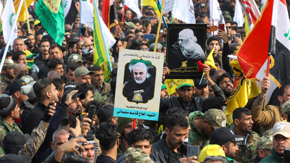 Supporters of the Hashed al-Shaabi paramilitary force and Iraq's Hezbollah brigades attend the funeral of Iranian military commander Qasem Soleimani (portrait) and Iraqi paramilitary chief Abu Mahdi a