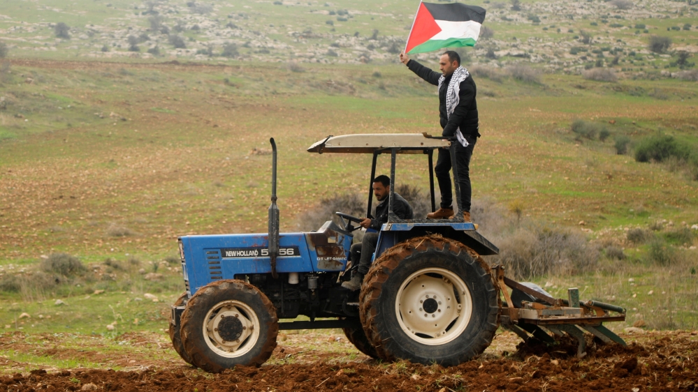 A demonstrator holding a Palestinian flag rides on a tractor during a protest against the U.S. president Donald Trump’s Middle East peace plan, in Jordan Valley in the Israeli-occupied West Bank