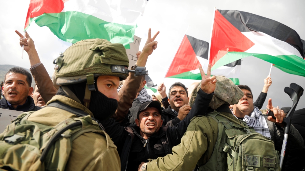 Palestinian demonstrators gesture in front of Israeli forces during a protest against the U.S. president Donald TrumpÕs Middle East peace plan, in Jordan Valley in the Israeli-occupied West Bank