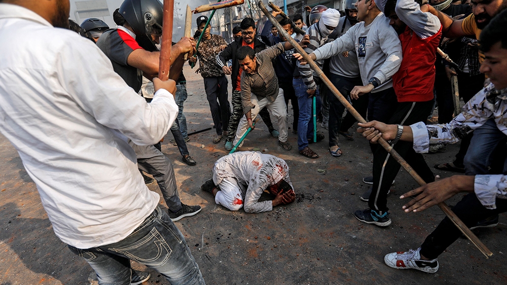 SENSITIVE MATERIAL. THIS IMAGE MAY OFFEND OR DISTURB    People supporting the new citizenship law beat a Muslim man during a clash with those opposing the law in New Delhi, India, February 24, 2020. R