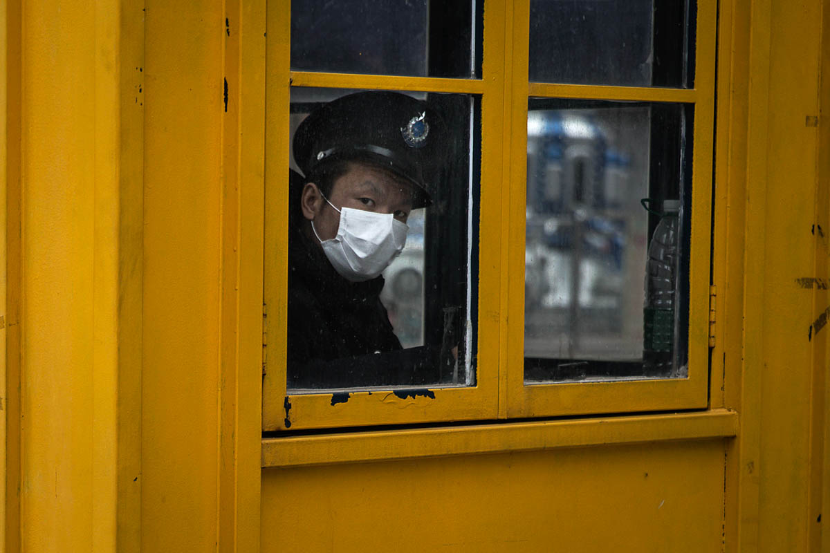 WUHAN, CHINA - FEBRUARY 07: A security guard looks out of the window of a sentry box on February 7, 2020 in Wuhan, Hubei province, China. The number of those who have died from the Wuhan coronavirus,