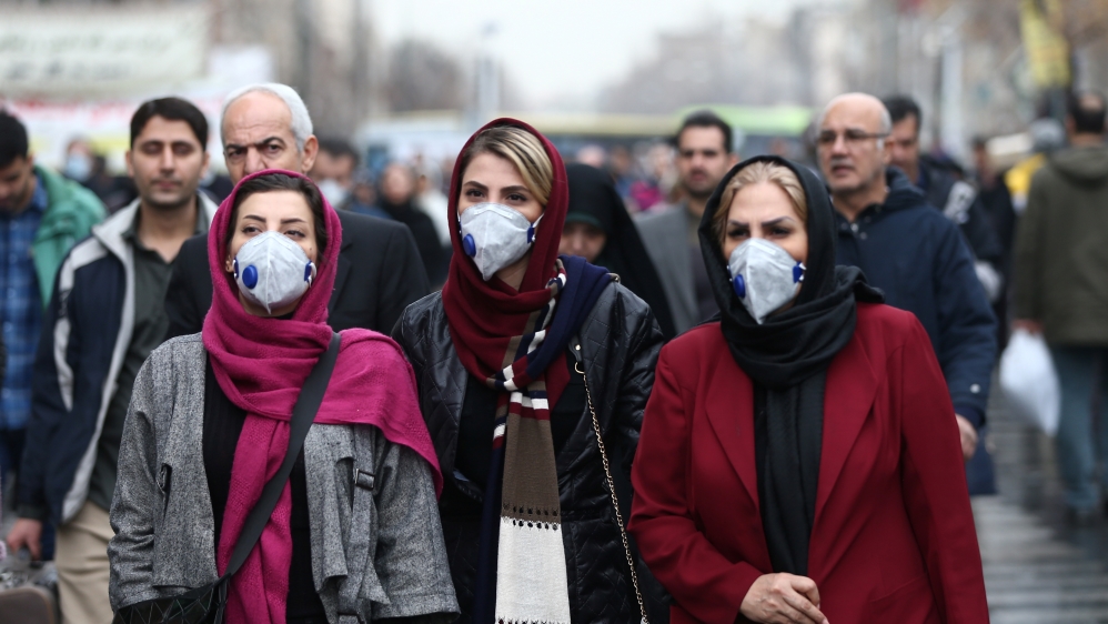 Iranian women wearing protective masks to prevent contracting a coronavirus walk at Grand Bazaar in Tehran