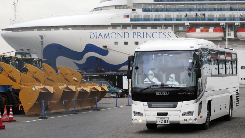 A driver wearing protective suits is seen inside a bus which believed to carry elderly passengers of the cruise ship Diamond Princess, where dozens of passengers were tested positive for coronavirus, 
