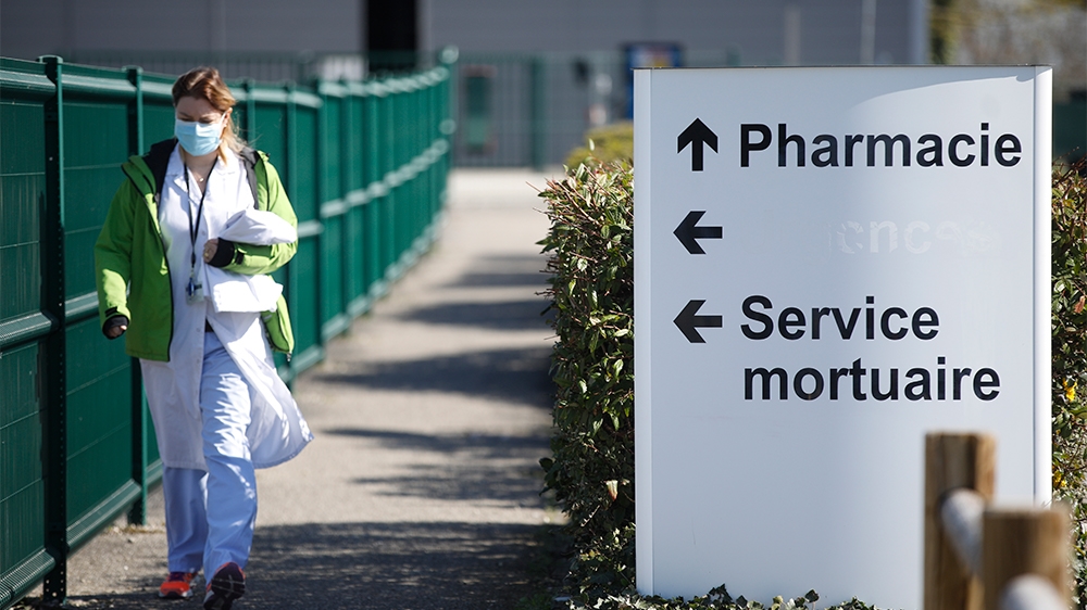 A medical staff walks by the civil hospital in Mulhouse, eastern France, Tuesday, March 24, 2020. The Grand Est region is now the epicenter of the outbreak in France, which has buried the third most v