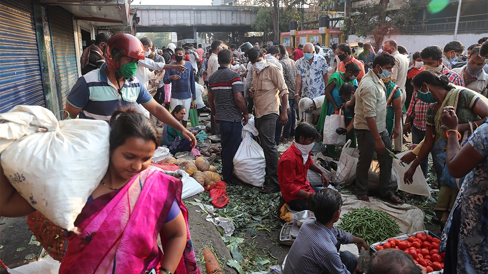 Indians crowd a vegetable market in Mumbai, India, Wednesday, March 25, 2020. The world's largest democracy went under the world's biggest lockdown Wednesday, with India's 1.3 billion people ordered t