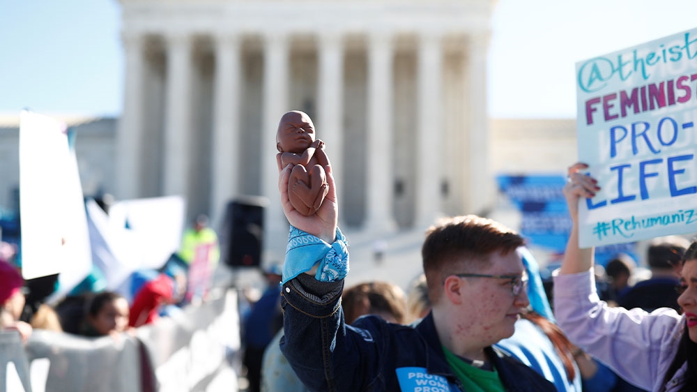 An anti-abortion demonstrator holding a mock human foetus outside the US Supreme Court during a protest on Capitol Hill in Washington, DC