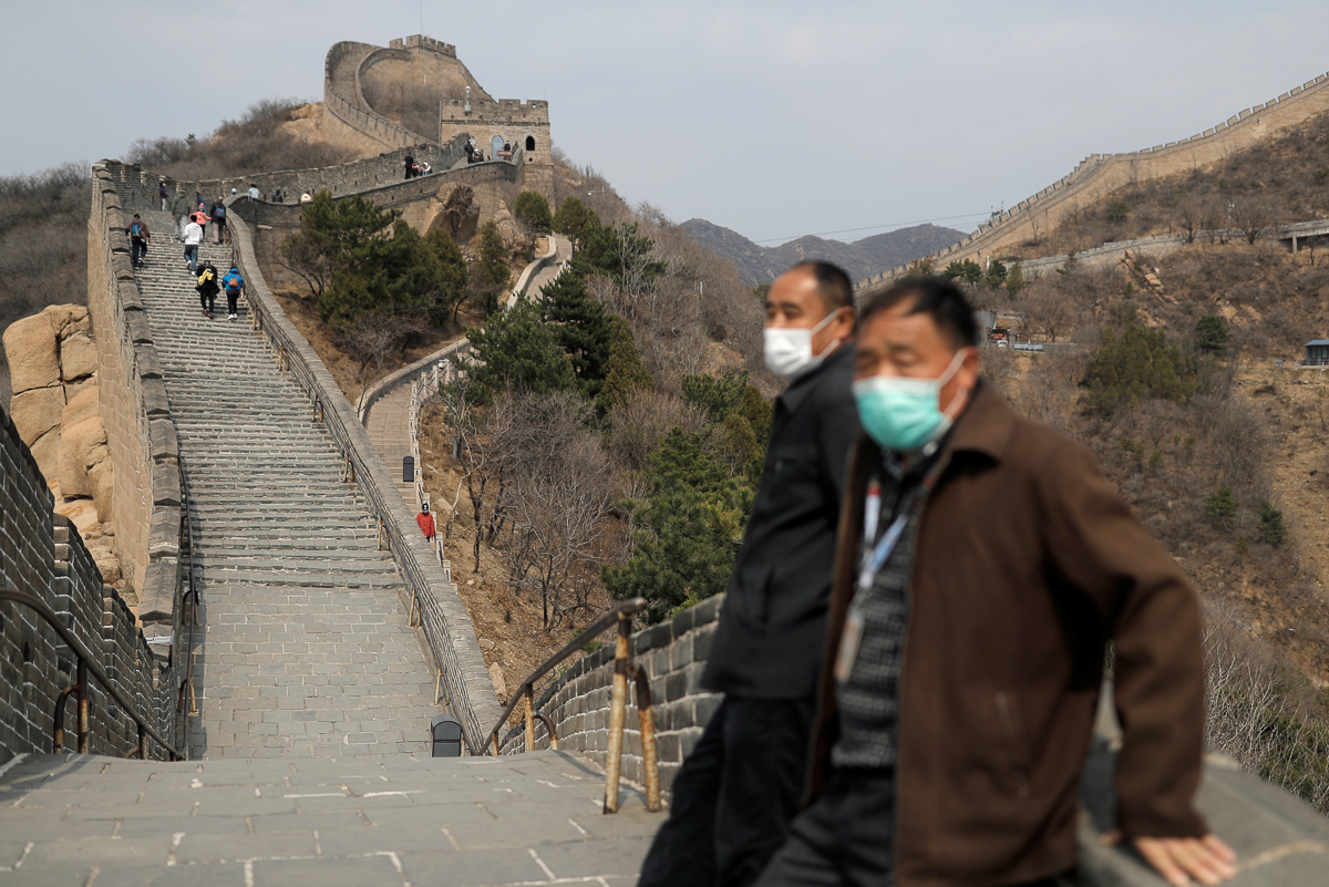 Men wearing protective masks stand as people hike along a section of the Great Wall in Badaling in Beijing, on its first day of re-opening after the scenic site''s coronavirus related closure, China, M