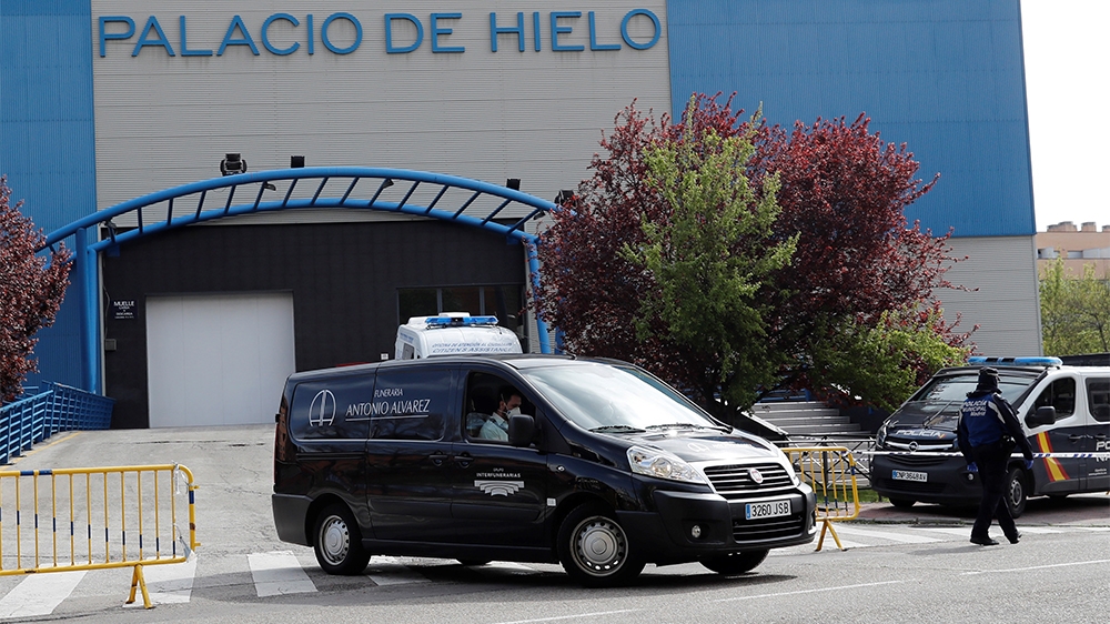epa08317566 A hearse (C) leaves Palacio de Hielo ice skating center and shopping mall in Madrid, Spain, 24 March 2020. The facilities will be used as a morgue for coronavirus fatalities amid coronavir