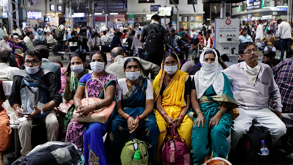 Indians waiting at a train station wear protective masks as a precaution against a new virus outbreak in Mumbai, India, Tuesday, March 17, 2020. For most people, the new coronavirus causes only mild o
