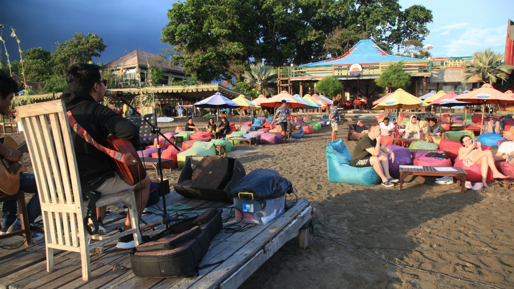 Bali’s remaining tourists hang out at bars along the beach {Al Jazeera] [Al
