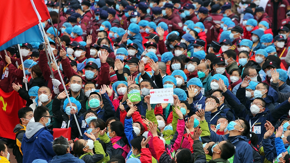 epa08282314 Medical workers celebrate the shutting down of Jianghan Fangcang temporary hospital for COVID-19 patients in Wuhan, Hubei province, China, 09 March 2020 (issued 10 March 2020). As the numb