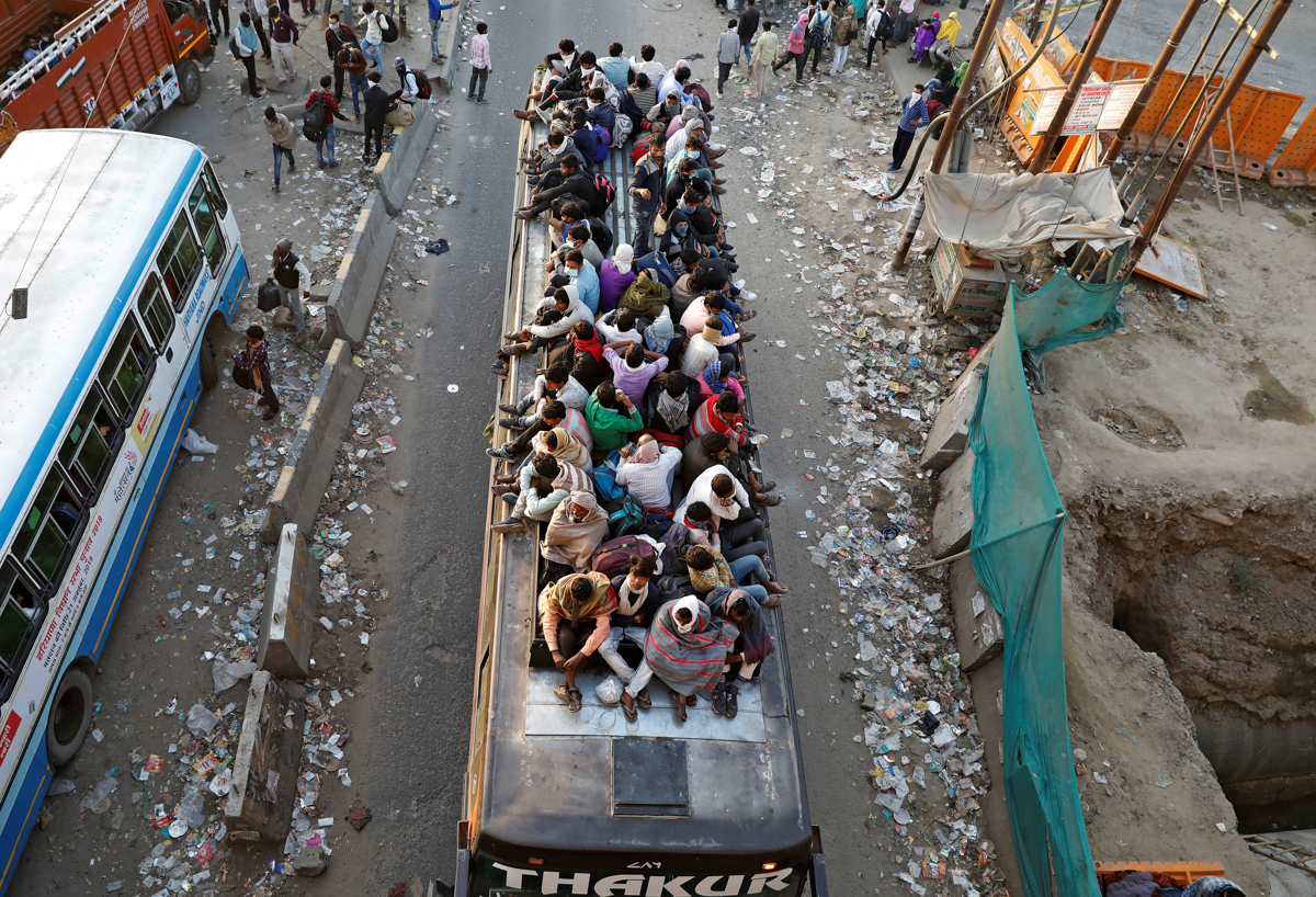 Migrant workers travel on a crowded bus as they return to their villages, during a 21-day nationwide lockdown to limit the spreading of coronavirus disease (COVID-19), in Ghaziabad, on the outskirts o