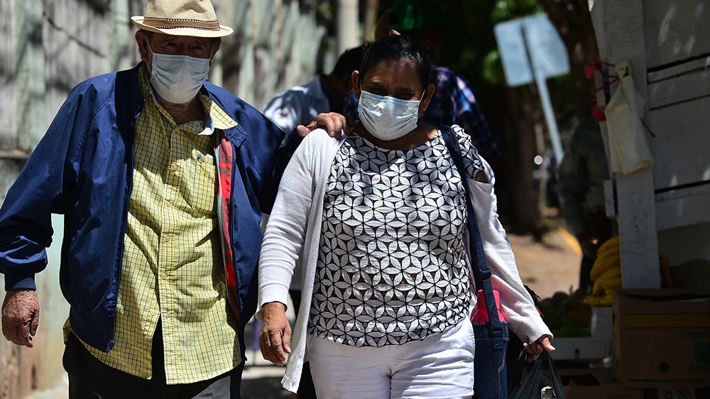 A couple wear protective face masks to prevent the spread of the new coronavirus as they head to the National Cardiopulmonary Hospital, in Tegucigalpa